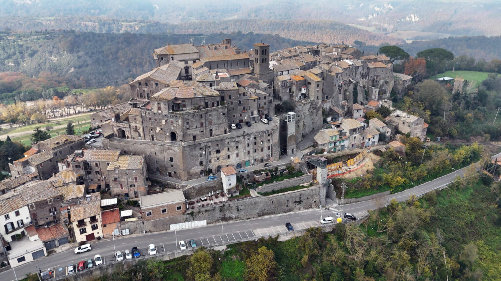 Maestosa vista di Bomarzo: il centro storico medievale troneggia su un costone roccioso, circondato da dolci colline e dalla natura.