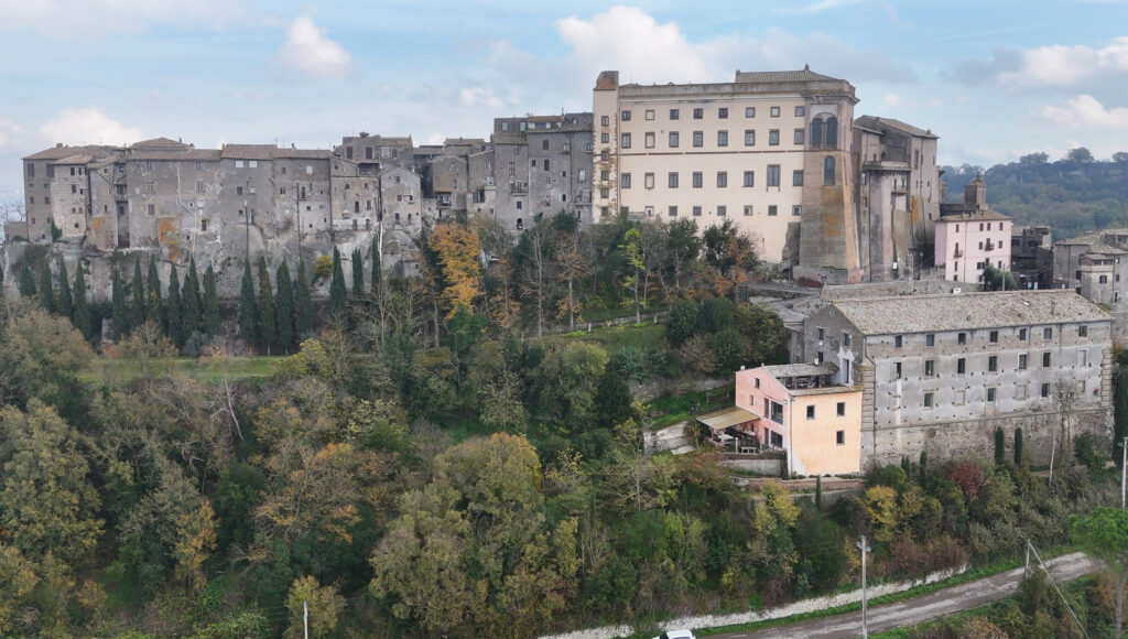 Vista da drone di Palazzo Orsini e del centro storico di Bomarzo, circondati da un paesaggio autunnale.