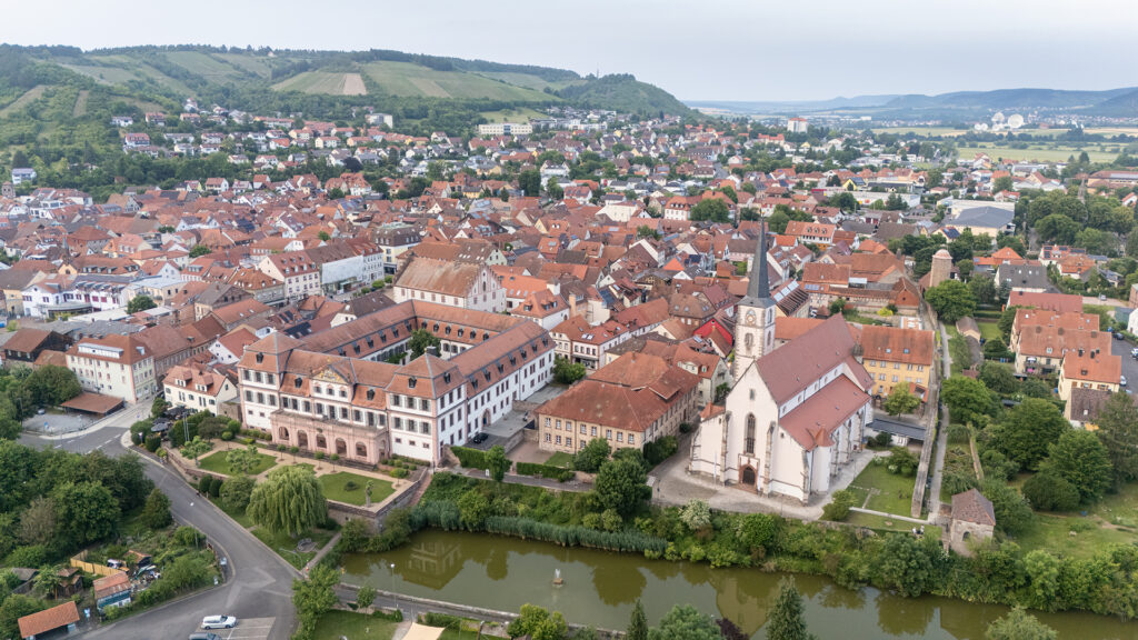 Aerial view of Hammelburg showing the historic town centre with the Kellereischloss, church architecture and red rooftops set within the rolling landscape of Lower Franconia, Germany.